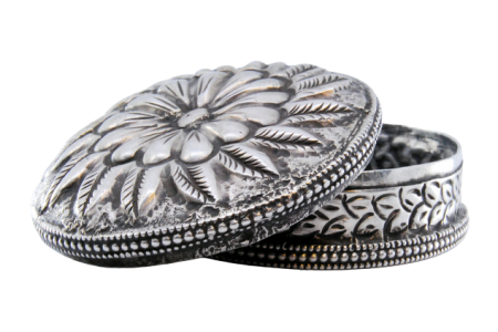 Caixa de comprimidos em prata de forma circular com motivos vegetalistas relevados na tampa amovível.